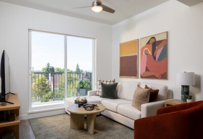 Bright living room with balcony access and framed artwork in an Abode rental home